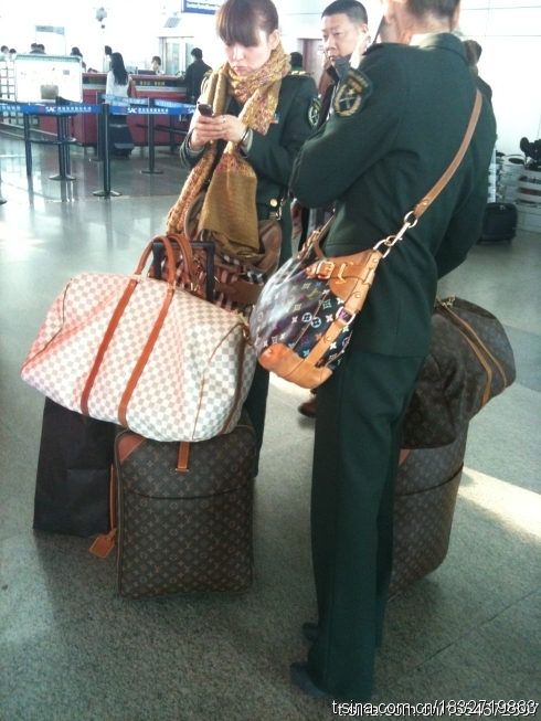 Chinese female soldiers traveling with Louis Vuitton bags and suitcases.