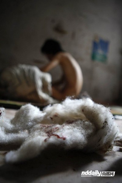 Cotton wadding with traces of blood litter Wu Guilin's filthy home.
