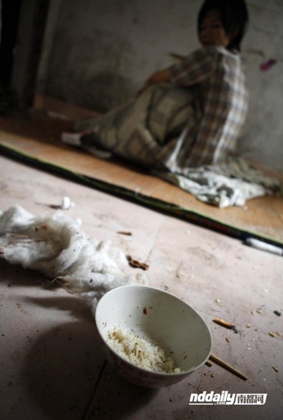 A bowl of dried leftover rice near Wu Guilin's mat that serves as his bed.