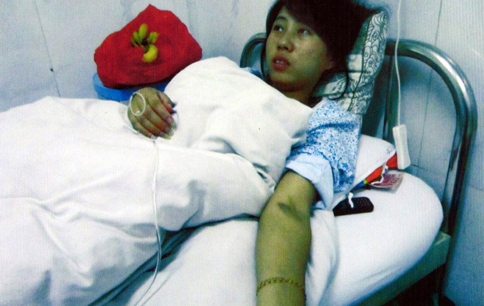 Feng Jianmei lying on a hospital bed. For violating China's One-Child