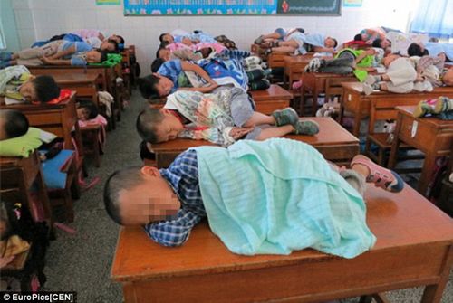 elementary-students-taking-a-nap-on-their-classroom-desks-01.jpg