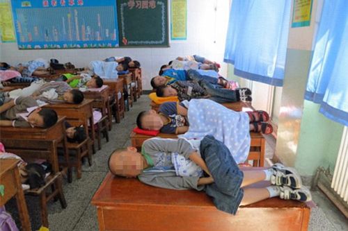 elementary-students-taking-a-nap-on-their-classroom-desks-03.jpg
